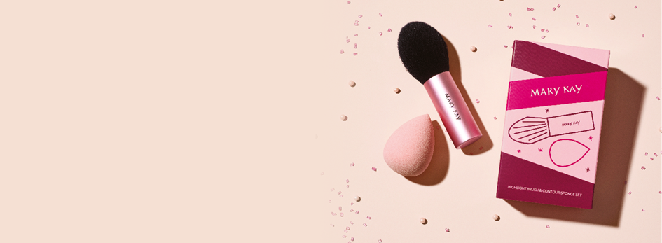 Omgeven door pinke confetti ligt de Mary Kay® Highlight Brush and Contour Sponge Set buiten zijn hoogwaardige verpakking voor een teerroze achtergrond.  