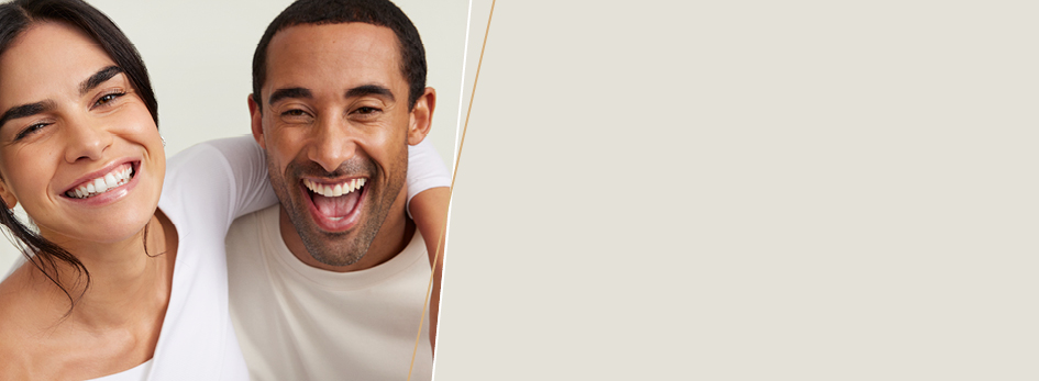 Een vrouw omhelst een man - beiden glimlachen blij in de camera