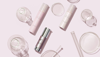 Drie Mary Kay gezichtsserums en reageerbuisjes liggen op een pink oppervlak