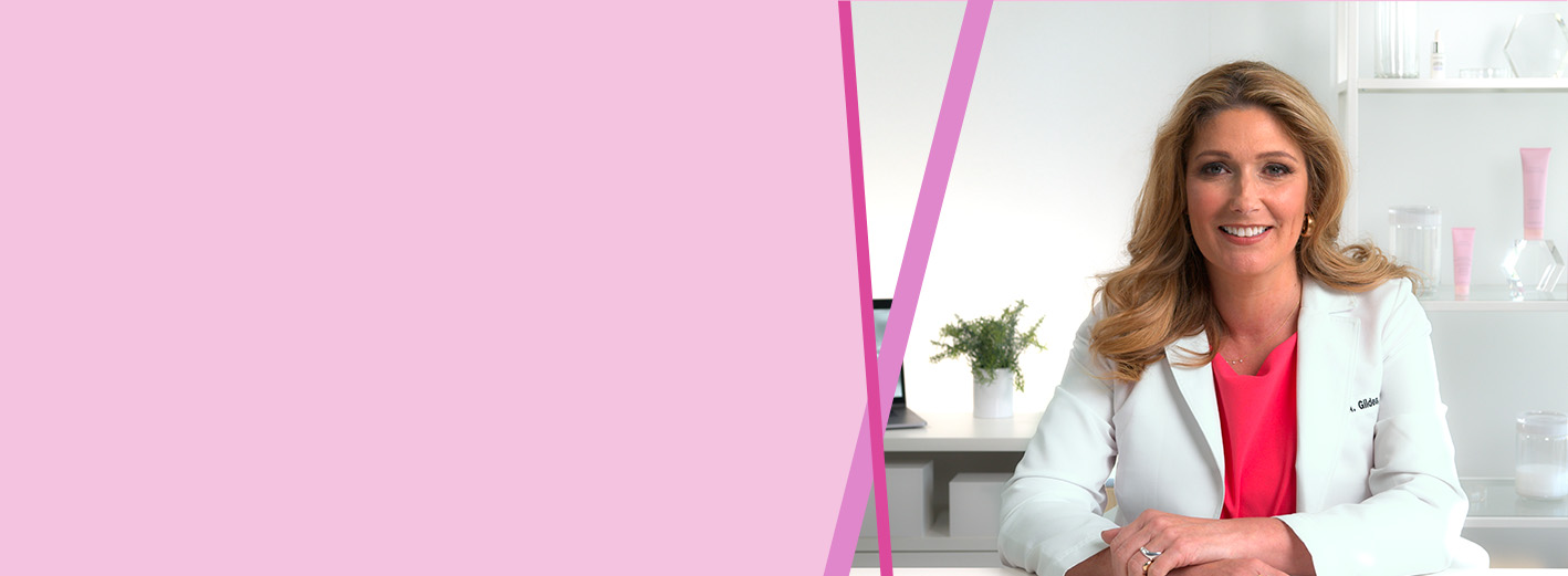 Mary Kay wetenschapper Dr. Lucy Gildea zit aan een tafel met Mary Kay producten op de achtergrond