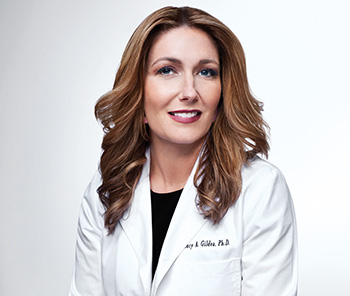 Een portret van Mary Kay wetenschapper dr. Lucy Gildea in een witte laboratoriumjas