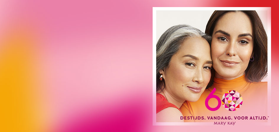 Twee dames met decente make-up staan dicht bij elkaar en glimlachen. De tekst “Destijds. Nu. Voor altijd” is in pinke schrift in de hoek rechts onderaan te zien.