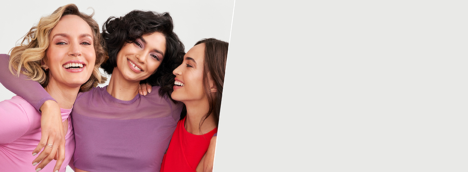 Drie vrouwen omhelzen elkaar en glimlachen