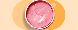 Een geopend potje  met  Mary Kay® Hydrogel Eye Patches inclusief gebruiksspatel ligt op een beige  achtergrond.