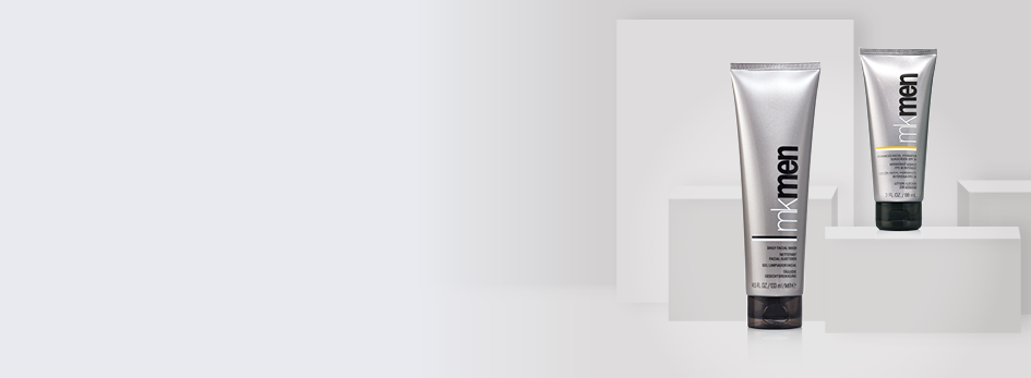 De MK Men® Daily Facial Wash en de MK Men® Advanced Facial Hydrator Sunscreen SPF 30 staan tegen een grijze achtergrond. De huiderzorgingsproducten in de zilveren tubes behoren tot de Mary Kay mannencollectie.
