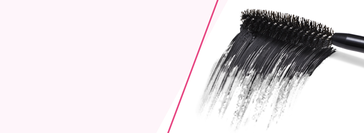 Close-up van een mascaraborsteltje met zwart gepigmenteerd product. 