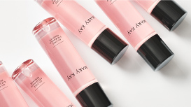 Zes Mary Kay Oil-Free Eye Makeup Remover flesjes diagonaal op een oppervlak verdeeld.
