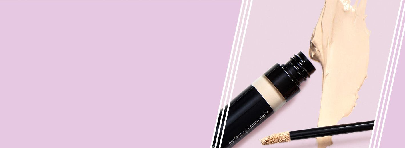 Een geopende Mary Kay Perfecting Concealer met applicator en productklodders op een violette ondergrond