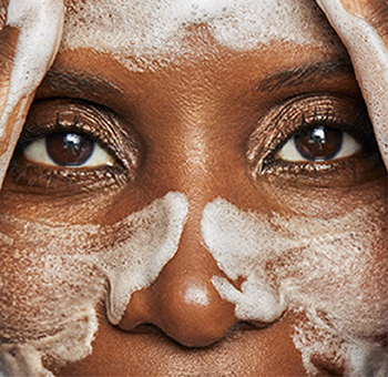  Close-up van een vrouw met schuim op haar gezicht die haar gezicht met haar handen wast