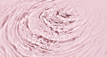 Roze waterdruppels die voor vochtverzorging bij de droge huid staan
