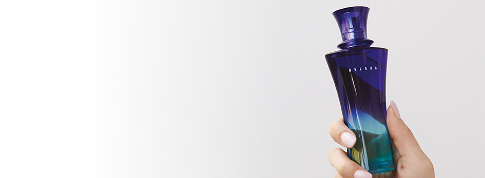 Een goed verzorgde vrouwenhand houdt het flesje Belara® Eau de Parfum van Mary Kay in de lucht.