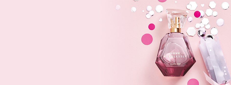 Het flesje Love Fearlessly® Eau de Parfum van Mary Kay ligt op een roze achtergrond samen met roze en witte confetti.