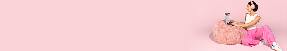 Een vrouw zit op de grond en werkt op haar laptop