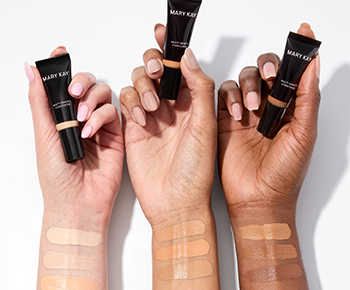 Drie handen houden elk een tube Mary Kay Multi-Benefit Concealer in een verschillende kleur. Op de armen zijn drie kleuren uitgeprobeerd.