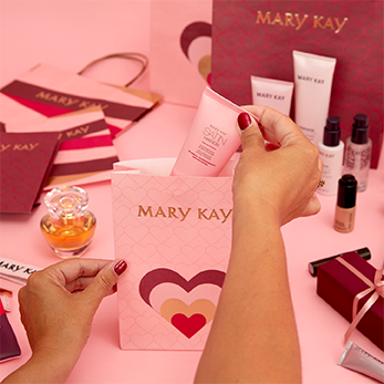 Op een roze tafel zie je enkele cadeauzakjes die worden gevuld met Mary Kay producten