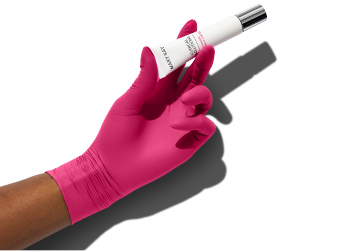Een hand met een roze handschoen houdt het product Clinical Solutions Dynamic Wrinkle Limiter van Mary Kay vast op de foto