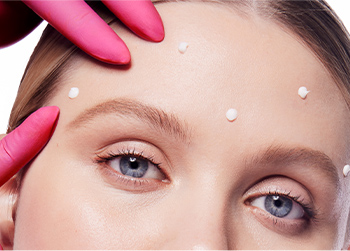 Kleine hoeveelheden Mary Kay Clinical Solutions Dynamic Wrinkle Limiter worden aangebracht op vijf punten op het voorhoofd van een vrouw