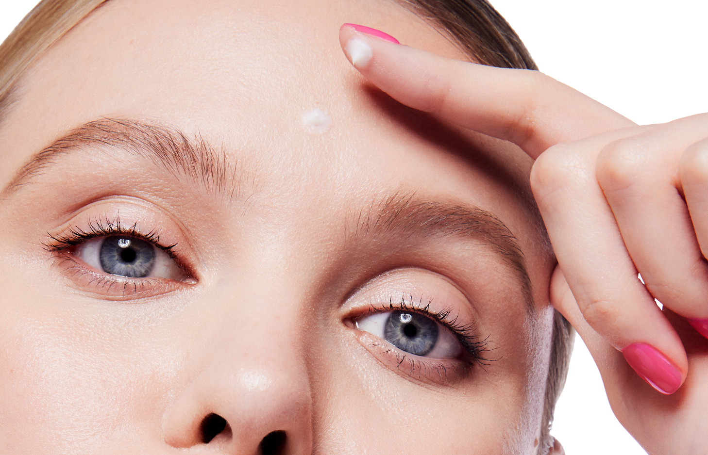 Een vrouw brengt met haar vinger een kleine hoeveelheid Clinical Solutions Dynamic Wrinkle Limiter aan op de dynamische expressierimpels op haar voorhoofd