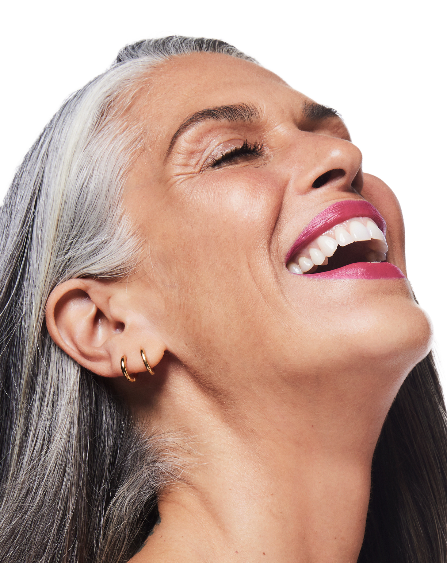 Een vrouw lacht hartelijk - de expressielijnen op haar gezicht zijn zichtbaar, veroorzaakt door gezichtsuitdrukkingen in de loop der jaren