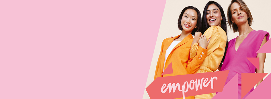 Drie stralende vrouwen gekleed in felle kleuren staan naast elkaar en omhelzen elkaar. De afbeelding heeft de inscriptie "empower".